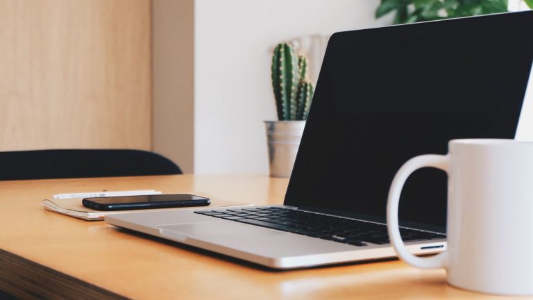 MacBook, coffee mug, and cactus