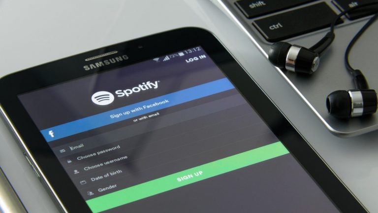 Spotify on a smartphone with earbuds