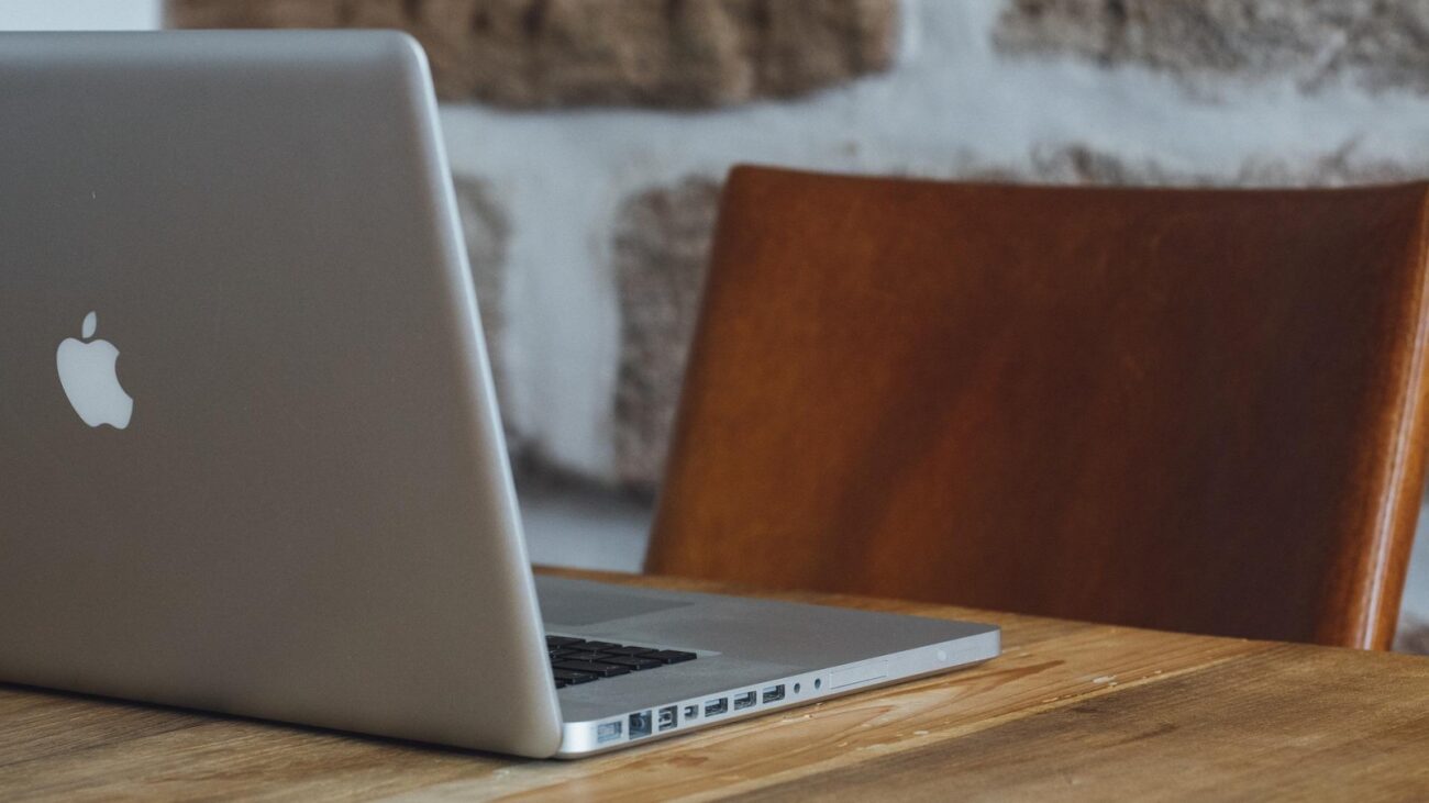 MacBook at a desk with an empty chair
